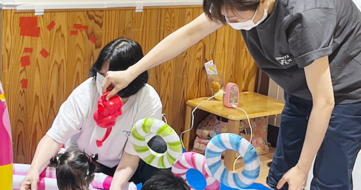 看護師がじょうろを使って、こどもに優しく水をかけています。